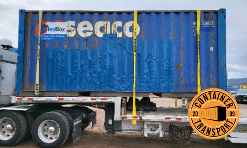 shipping container strapped to trailer